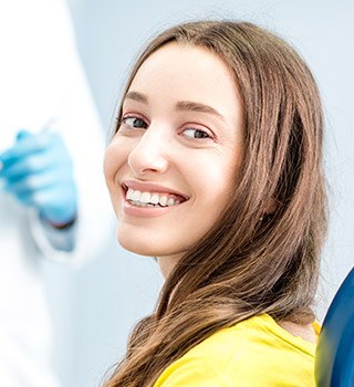 Smiling young woman in dental chair