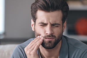 Man holding jaw in pain